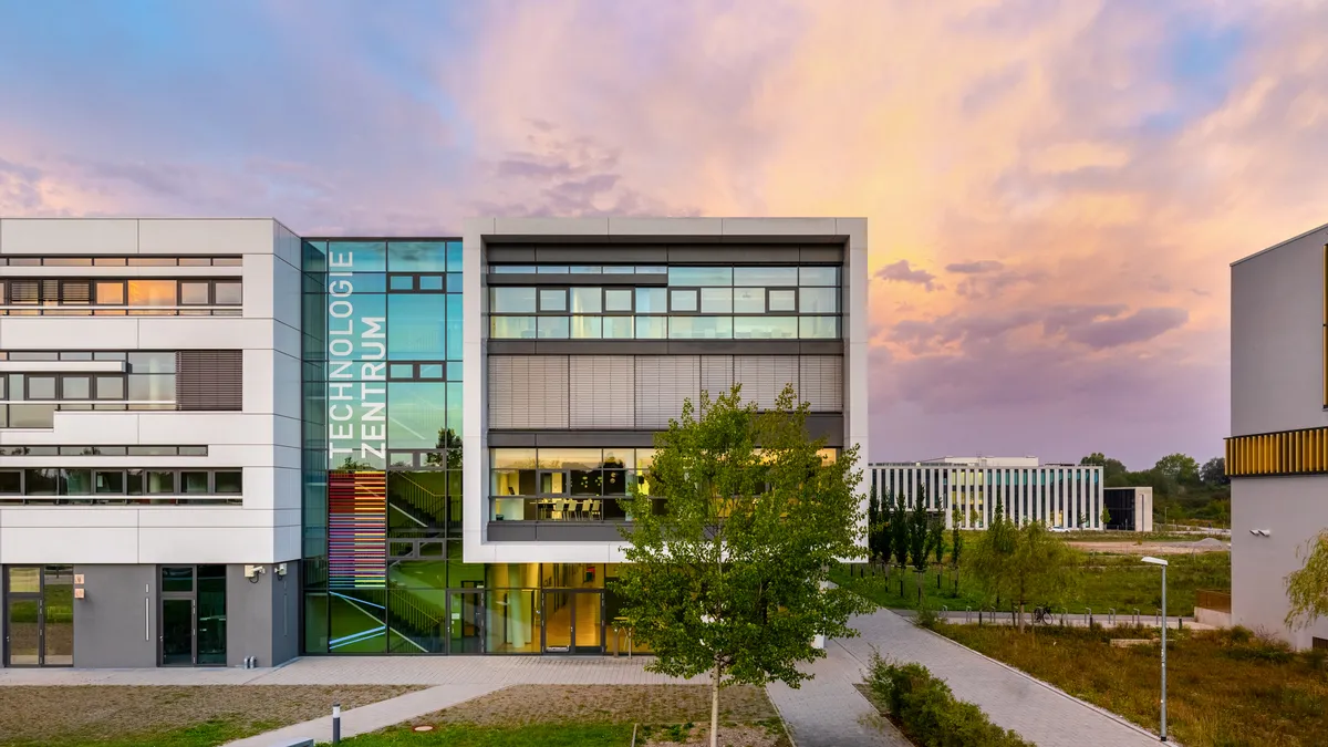Technology Centre Augsburg at sunrise, with the lettering “Technologiezentrum” on the glass façade
