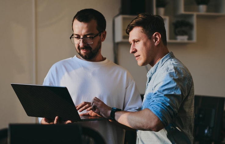 Two software developers working together on code at a laptop
