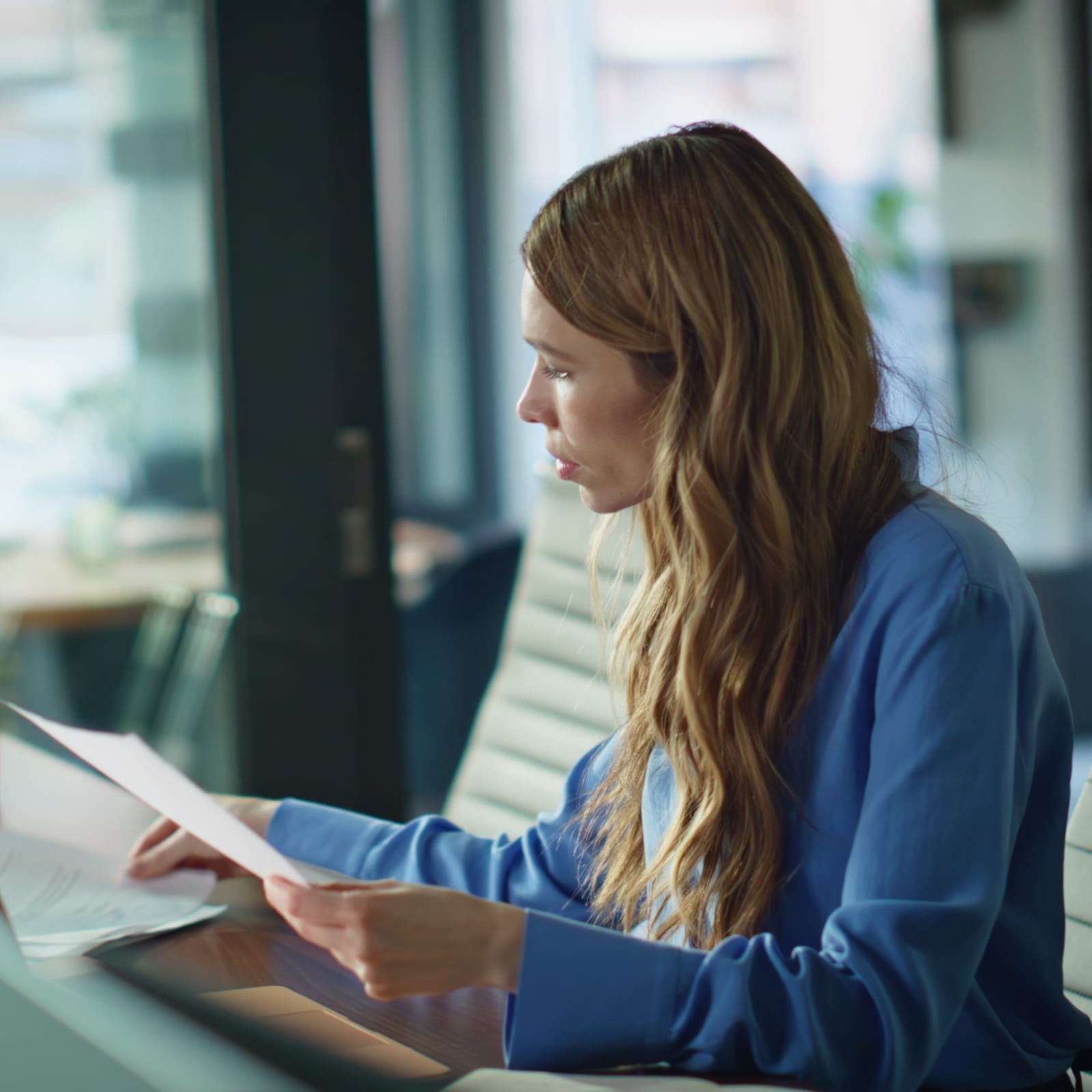 Woman reviewing documents at her office desk